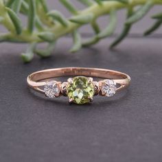 a yellow and white diamond ring sitting on top of a table next to a plant