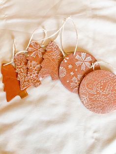 four orange and white ornaments are hanging from string