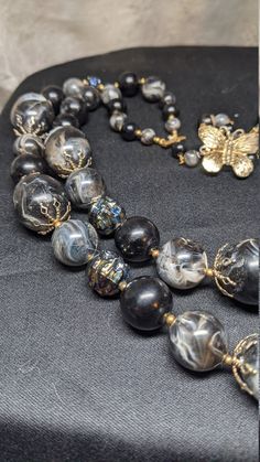 "FREE SHIPPING- Vintage Multi Strand Necklace with Gold Tone Accents and Marbled Black Acrylic & Resin Beads. See Item Description for Important info! Great Condition~! There is a Maker's Mark signature under the Hook on the Butterfly, but it is hard to make out. Measures 26-1/2\" Long FREE SHIPPING FOR ALL ORDERS GOING TO THE CONTINENTAL U.S.A (LOWER 48 STATES) ALL PURCHASES DESTINED FOR ALASKA OR HAWAII WILL INCUR SHIPPING CHARGES PLEASE SEE OUR PHOTOS ABOVE FOR DETAIL & CONTACT US WIT Black Double Strand Beaded Necklaces For Jewelry Making, Black Round Beaded Costume Jewelry Necklace, Black Round Beads Costume Jewelry Necklace, Black Beaded Necklaces Costume Jewelry, Black Beaded Necklace Costume Jewelry, Vintage Black Beads For Gifts, Vintage Black Beads For Gift, Vintage Black Gemstone Beads Necklace, Vintage Black Beaded Necklace With Gemstone Beads