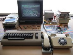 an old computer sitting on top of a wooden desk next to a keyboard and mouse