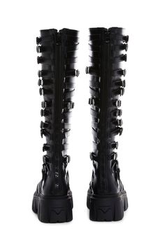 in a vegan leather construction. These knee high boots have decorative buckles on both sides, treaded soles, and back zipper closures. Black Punk Knee-high Boots With Buckle, Black Punk Knee-high Boots With Buckle Closure, Black Punk Style Knee-high Boots With Buckle, Black Knee-high Moto Boots With Zipper Closure, Gothic Leather Knee-high Boots, Edgy Knee-high Boots With Buckle Closure, Gothic Leather Knee-high Boots For Alternative Fashion, Punk Style Leather Knee-high Boots With Buckle, Alternative Style Boots With Buckle Closure