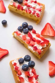 three pieces of cake with strawberries and blueberries on top