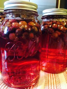 three jars filled with red liquid sitting on top of a table