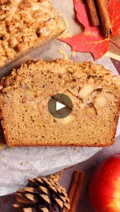 a loaf of apple cinnamon bread next to an apple, cinnamon sticks and autumn leaves