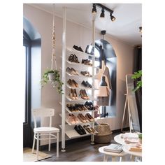 a shoe rack with several pairs of shoes hanging from it's sides in a living room