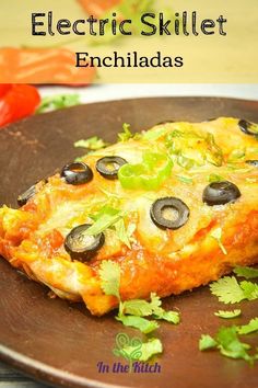 an enchiladas dish with black olives and cilantro on top