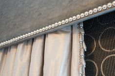 an upholstered bed with silver studded trim