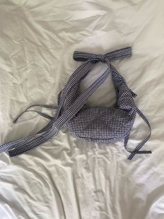 a blue and white checkered bag laying on top of a bed