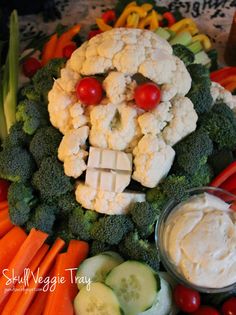 a platter with cauliflower, broccoli, carrots and cucumbers