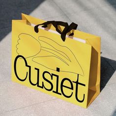 a yellow paper bag with the word cusiet written in black ink on it