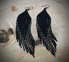 two pairs of black beaded earrings with turquoise beads and fringes hanging from them