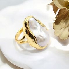 🌟 Elevate Your Elegance with Our Natural White Baroque Pearl Ring! 🌟 Indulge in the timeless beauty of our adjustable gold-plated ring, featuring a stunning white baroque pearl. This luxurious piece combines natural elegance with a touch of sophistication, perfect for the modern woman who appreciates classic style. ✨ Features: * Natural White Baroque Pearl: Each pearl is unique, adding to the charm of this elegant ring. * Adjustable Gold-Plated Band: Ensures a comfortable fit for any finger si Exquisite Gold Wedding Rings, Exquisite Gold Baroque Jewelry, Adjustable Gold Pearl Ring For Formal Occasions, Heirloom Baroque Jewelry For Weddings, Elegant Gold Pearl Ring As A Gift, Heirloom Style Gold Pearl Open Ring, Unique Yellow Gold Pearl Ring For Wedding, Heirloom Gold Pearl Open Ring, Exquisite Baroque Wedding Jewelry