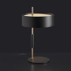 a table lamp with a black shade on the base and a white light in the middle