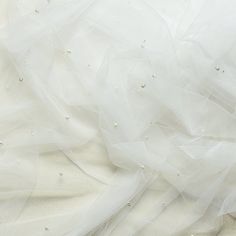 a white wedding dress with pearls on it