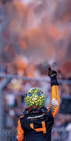 a man in black and orange jacket raising his fist