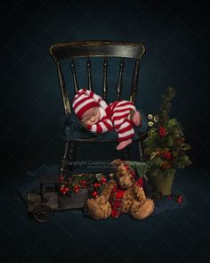 a baby sleeping on top of a chair next to teddy bears and christmas tree decorations