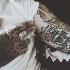 a man with tattoos on his arm and hand