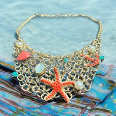 This is a perfect vintage gold starfish  Beach necklace. It has many little  Charms and a large coral cabochon  Starfish as the main attraction. This is In good preloved condition. This would  Be a great gift idea or wonderful for A summer vacation trip. This is Amazing! Gold Starfish Necklaces For Vacation, Gold Shell Necklace With Starfish Charm For Summer, Ocean-inspired Starfish Necklace For Vacation, Star-shaped Necklaces For Beach Summer, Starfish Shell Necklace For Vacation, Gold Starfish Charm Necklace For Beach Season, Starfish Necklace With Lobster Clasp For Vacation, Ocean-inspired Starfish Shell Necklace For Summer, Gold Necklace With Starfish Charm For Beach Season