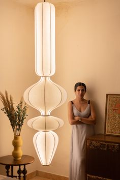 a woman standing in front of a light fixture