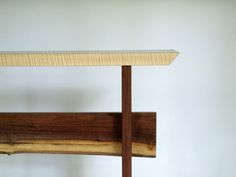 a wooden shelf sitting on top of a white wall