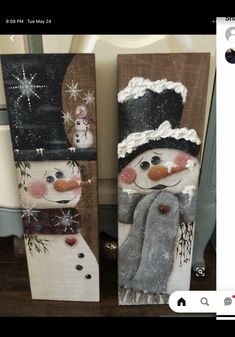 two snowmen painted on wooden boards sitting next to each other