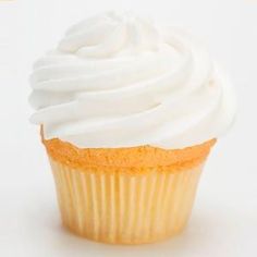 a cupcake with white frosting sitting on top of a table