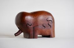 an elephant made out of wood sitting on top of a table