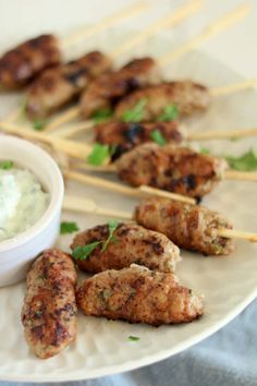 chicken skewers and dip on a white plate