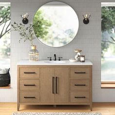 a bathroom with a round mirror above the sink