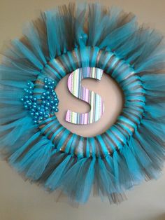 the letter s is made out of blue tulle and sits on top of a wall