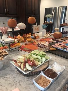 a table filled with lots of food on top of a kitchen counter next to wooden cabinets