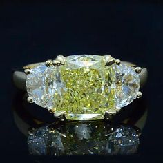 a fancy yellow diamond ring sitting on top of a table