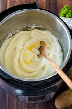 a pot filled with mashed potatoes on top of a wooden table