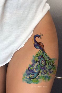 a woman's thigh with a peacock tattoo on it