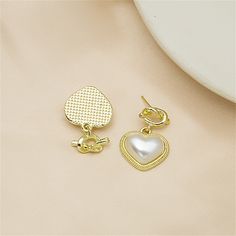 Take your accessory style up a notch with these drop earrings that feature a knot detail and heart-shaped pearls for a luxe look. 0.71" W x 0.87" L 18k gold-plated copper / pearL Gold Pearl Heart Earrings For Weddings, Gold Teardrop Heart Earrings In Elegant Style, Gold Teardrop Heart Earrings, Gold Pearl Earrings For Anniversary On Valentine's Day, Elegant Gold Teardrop Heart Earrings, Elegant Gold Heart-shaped Pearl Earrings, Valentine's Day Gold Pearl Earrings For Anniversary, Gold Heart-shaped Pearl Earrings For Pierced Ears, Gold Heart-shaped Earrings With Pearl Drop