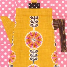 a pink and yellow polka dot quilt with a tea pot on it's side