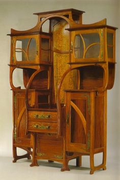 an old wooden cabinet with glass doors and drawers