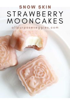 three strawberry mooncakes on a white plate with the words snow skin written above them