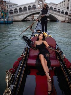 a woman in a black dress is sitting on a red and black gondola