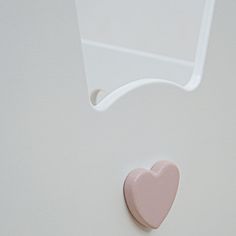 a heart shaped object is hanging on the wall