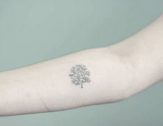 a small tree tattoo on the arm