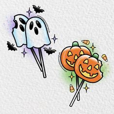 two halloween candy lollipops with faces on them and bats flying over them