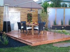 a wooden deck in the middle of a yard