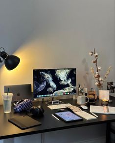 a desk with a laptop, monitor and phone on it next to a cup of coffee