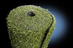 a roll of artificial grass on a black background