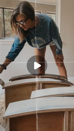 a woman is working on an unfinished bed frame