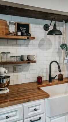 a kitchen with white cabinets and wooden counter tops, open shelving above the sink