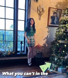 a woman standing in front of a christmas tree with the caption what you can't in the photo below