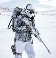 a man with a backpack and skis walking in the snow holding two ski poles