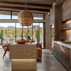 an open kitchen and dining area with large windows overlooking the desert landscape is shown in this rendering